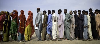 People line up to receive relief items. Pakistani authorities estimate it could take up to 6 months for floodwaters to recede in the hardest-hit areas.