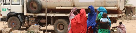 Women in Siti, Ethiopia wait by a water truck bringing humanitarian relief to tackle severe drought.