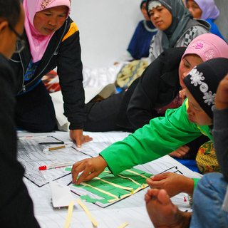 Community meeting discussing reconstruction of village hit by volcanic eruption.  Indonesia.